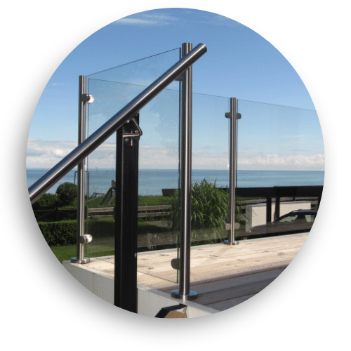 Modernes Glasgeländer mit Edelstahlpfosten und Handlauf auf Terrasse mit unverbautem Blick aufs Meer.