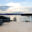 Glasbrüstung auf großzügiger Terrasse Weiße Glasbrüstung auf geräumiger Holzterrasse mit Ausblick auf Fjordlandschaft, Meer und Kreuzfahrtschiff.