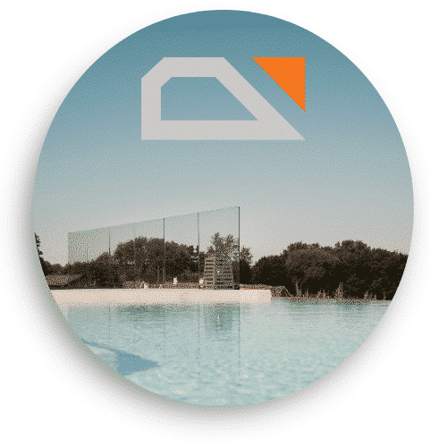 Spegelblank pool med ett vindskydd i glas i bakgrunden. Räcket är monterat med klämfästen och ger fri utsikt över omgivande träd och himmel. Räckesbutikens logotyp syns i övre delen av bilden.