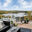 Glasgeländer mit Blick auf See und Wald Edelstahl-Glasgeländer auf Holzterrasse mit Panoramablick auf Herbstwald, See und Wohnsiedlung.