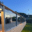 Glass Balustrade with Subtle LED Lighting Glass railing with grey posts and wooden handrail softly illuminated at dusk on an elevated deck with natural surroundings.