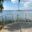 Glasgeländer mit Seeblick Glasgeländer aus Edelstahl auf Holzterrasse mit Panoramablick über den See und Blumen im Vordergrund.