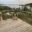 Glass Balustrade Overlooking Fjord Landscape Railing with steel posts placed on sloped wooden terrace featuring breathtaking fjord scenery and decorative outdoor lantern.