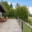 Schwarzes Glasgeländer an Blockhütte Glasgeländer mit schwarzen Aluminiumpfosten auf großer Holzterrasse bei Blockhaus im Wald.