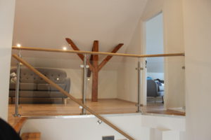 Glazen balustrade binnenshuis met houten leuning Glazen balustrade binnenshuis met houten leuning